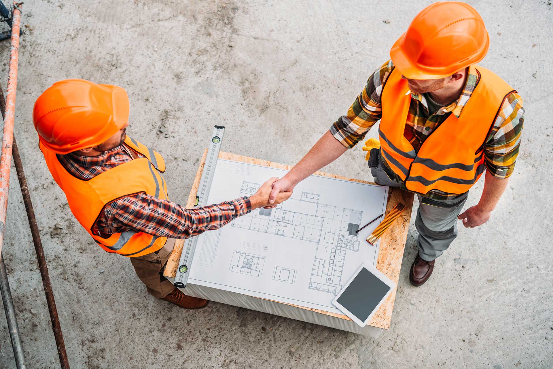 Top view of two engineers and contractor handshaking.