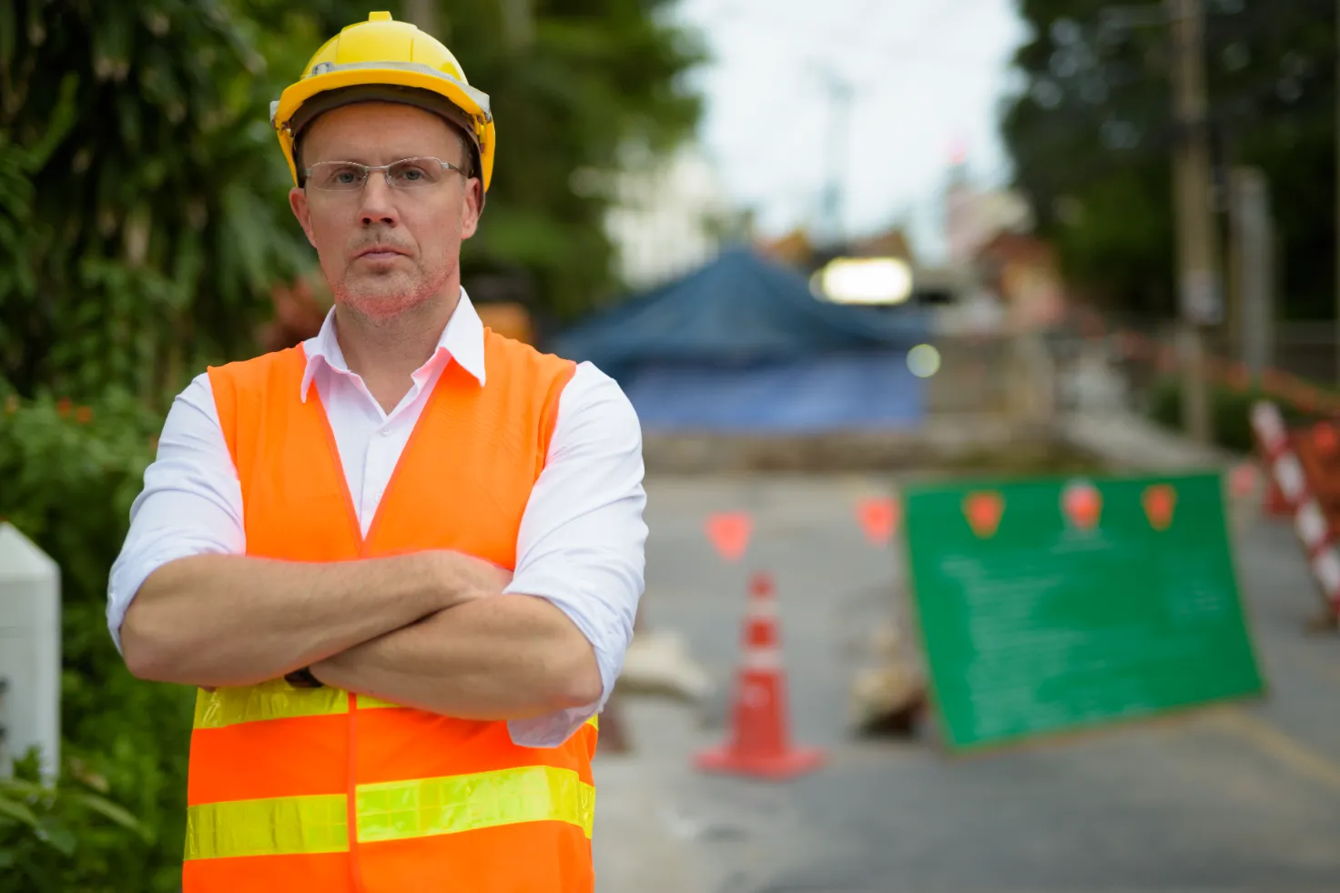 A contractor posing with arms crossed on the construction background.