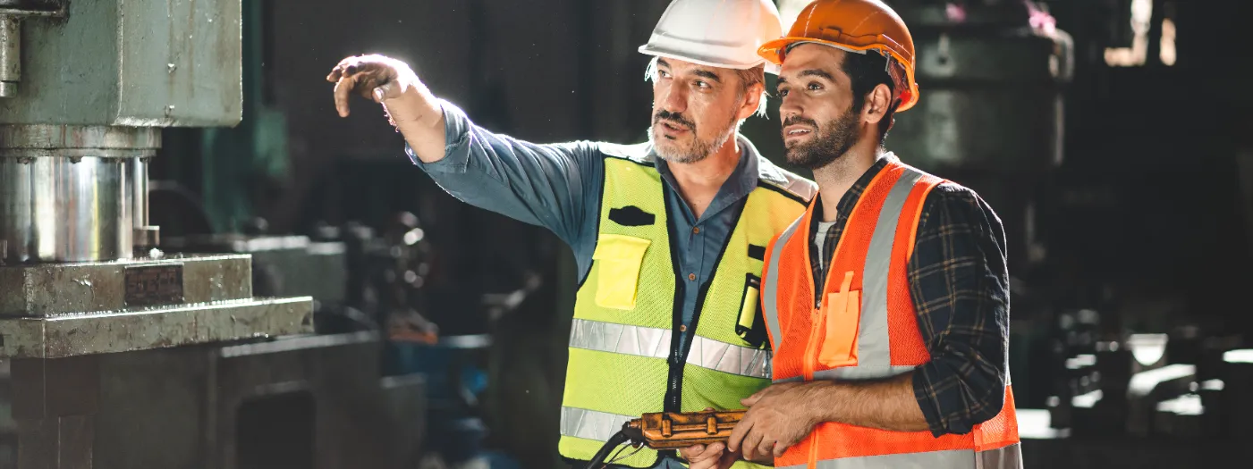 An engineer and a worker discussing the plan on the site.